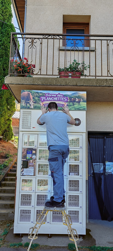 Pose de l’enseigne du casier réfrigéré au GAEC des Planchettes.